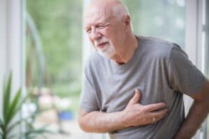 Senior grey man home alone having a heart attack