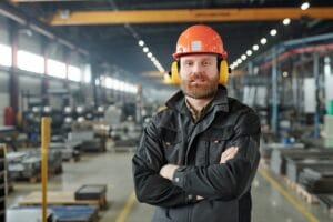 Bearded factory worker in ear protectors