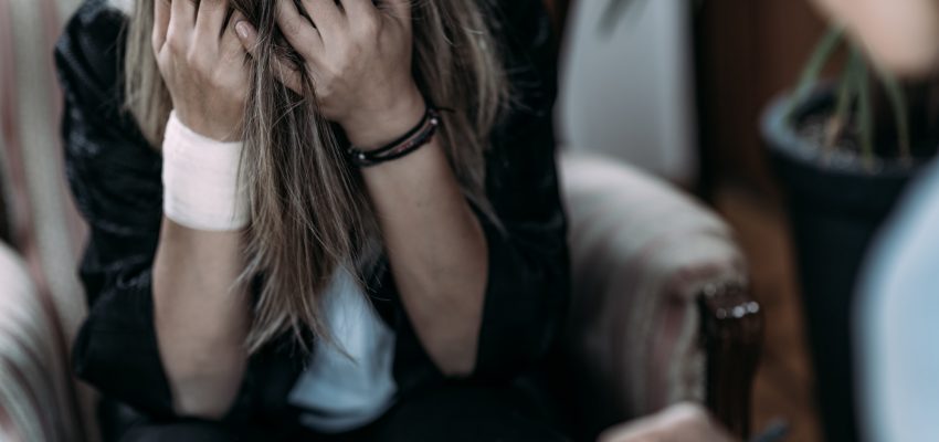 Female PTSD Patient Talking with Psychotherapist.